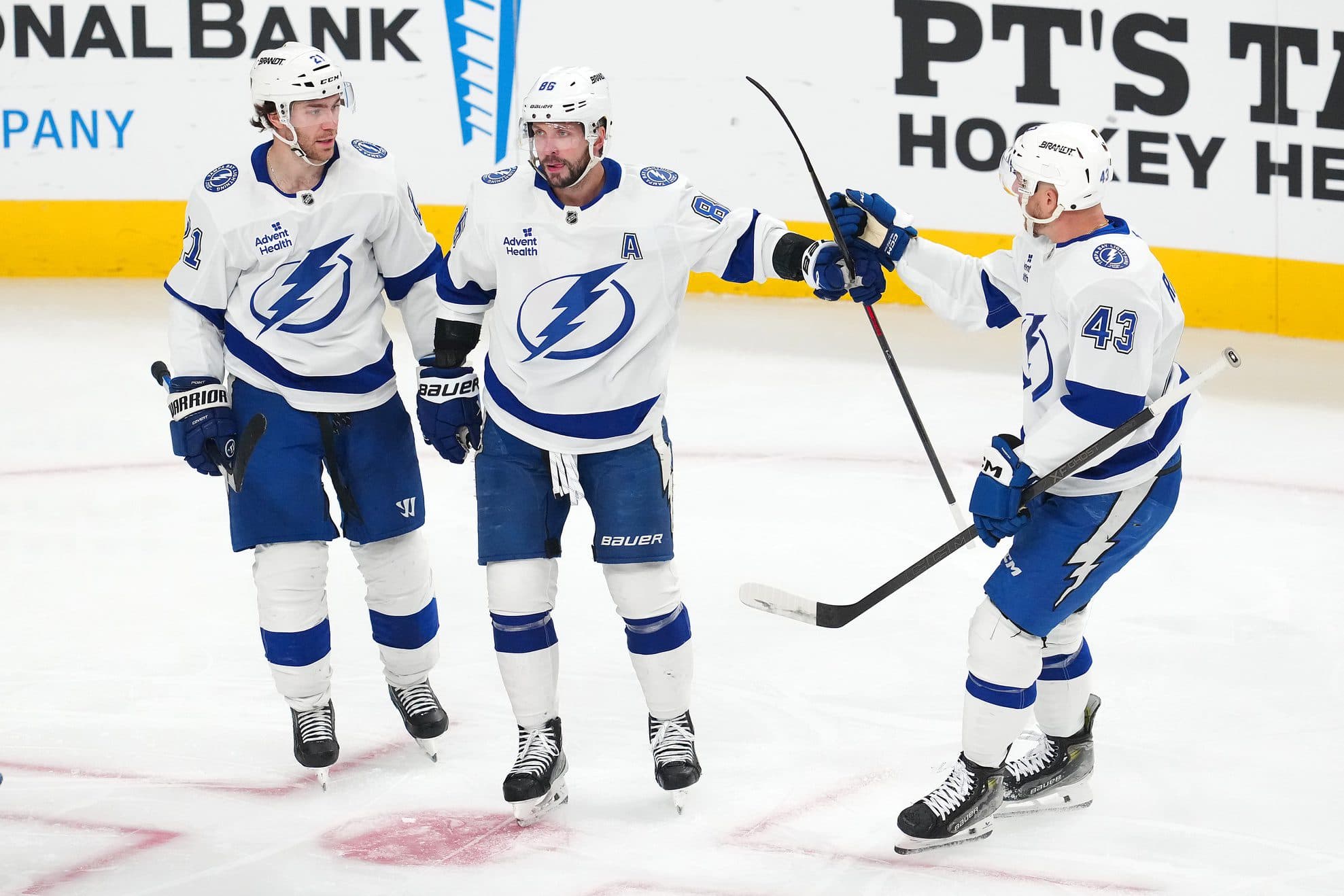 Tampa Bay Lightning right wing Nikita Kucherov (86) celebrates with center Brayden Point (21) and defenseman Darren Raddysh (43) after scoring a goal against the Vegas Golden Knights during the third period at T-Mobile Arena.