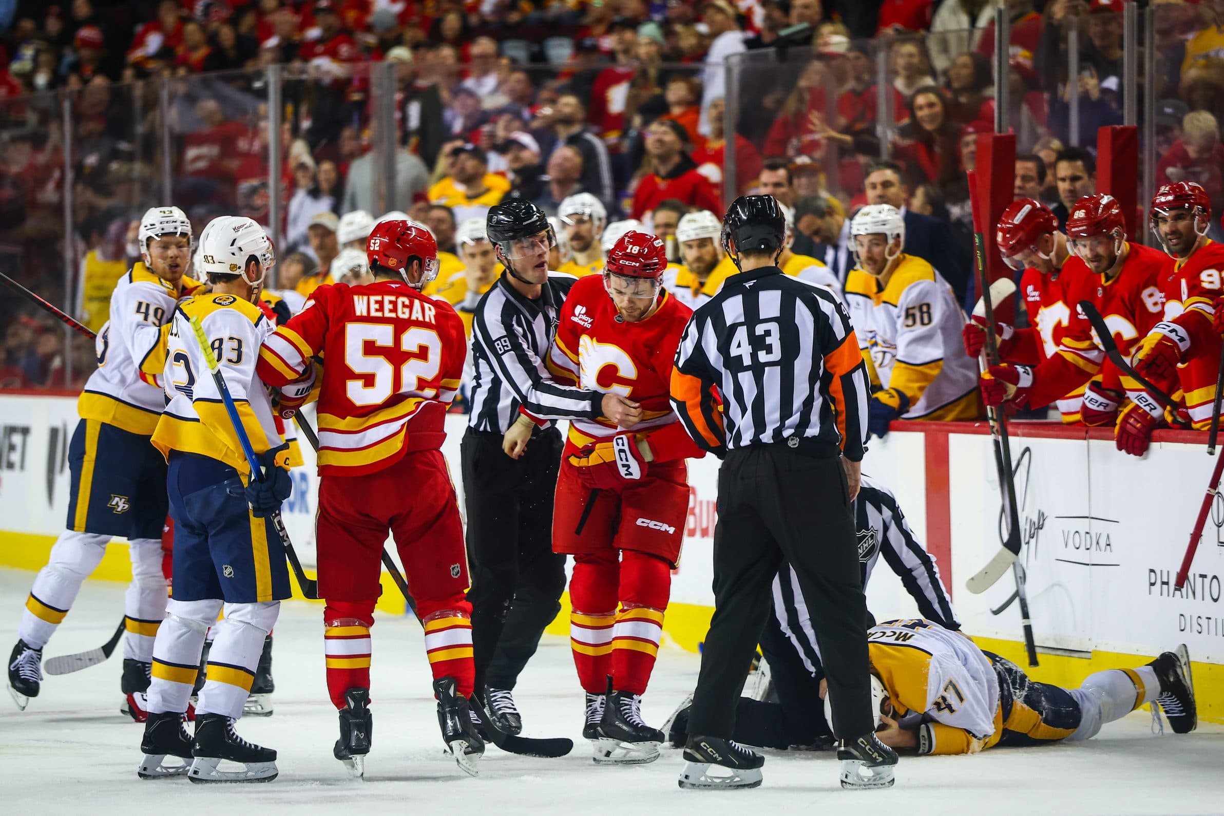Calgary Flames center John Beecher (18) and Nashville Predators right wing Michael McCarron (47) fight during the first period at Scotiabank Saddledome.