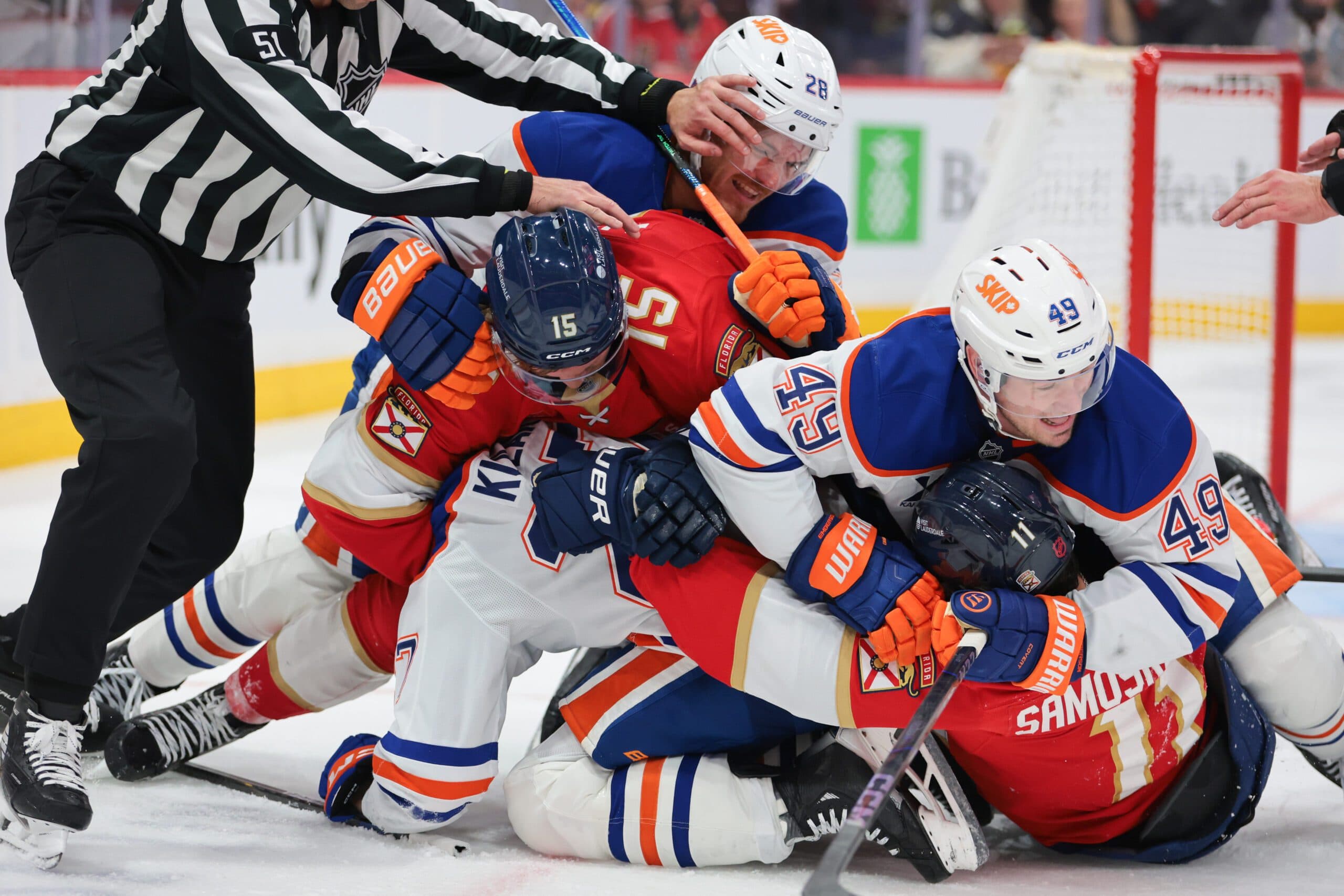 Nov 22, 2025; Sunrise, Florida, USA; Florida Panthers center Anton Lundell (15) and right wing Mackie Samoskevich (11) pile up during a scramble against Edmonton Oilers center Jack Roslovic (28) and defenseman Ty Emberson (49) during the third period at Amerant Bank Arena. Mandatory Credit: Sam Navarro-Imagn Images