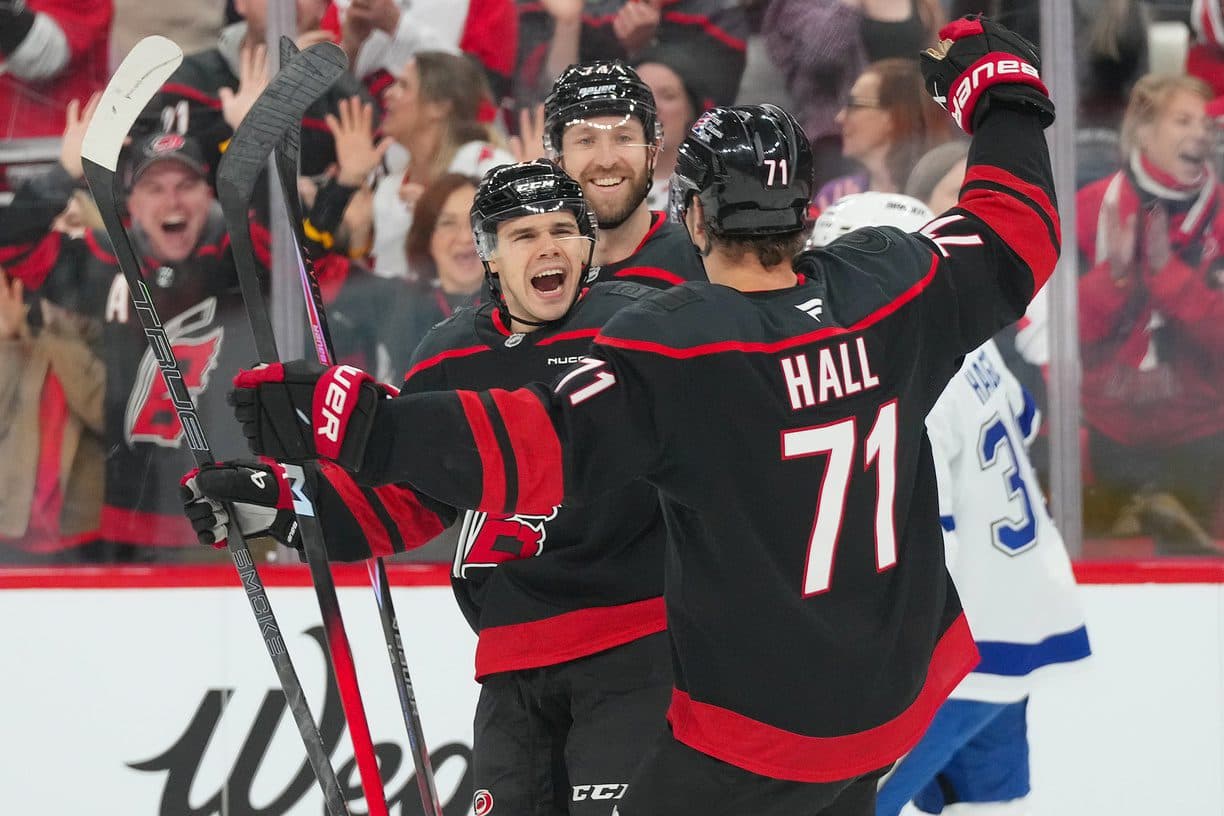 Carolina Hurricanes center Logan Stankoven (22) is congratulated by defenseman Jaccob Slavin (74) and left wing Taylor Hall (71) for his goal against the Tampa Bay Lightning during the first period at Lenovo Center.