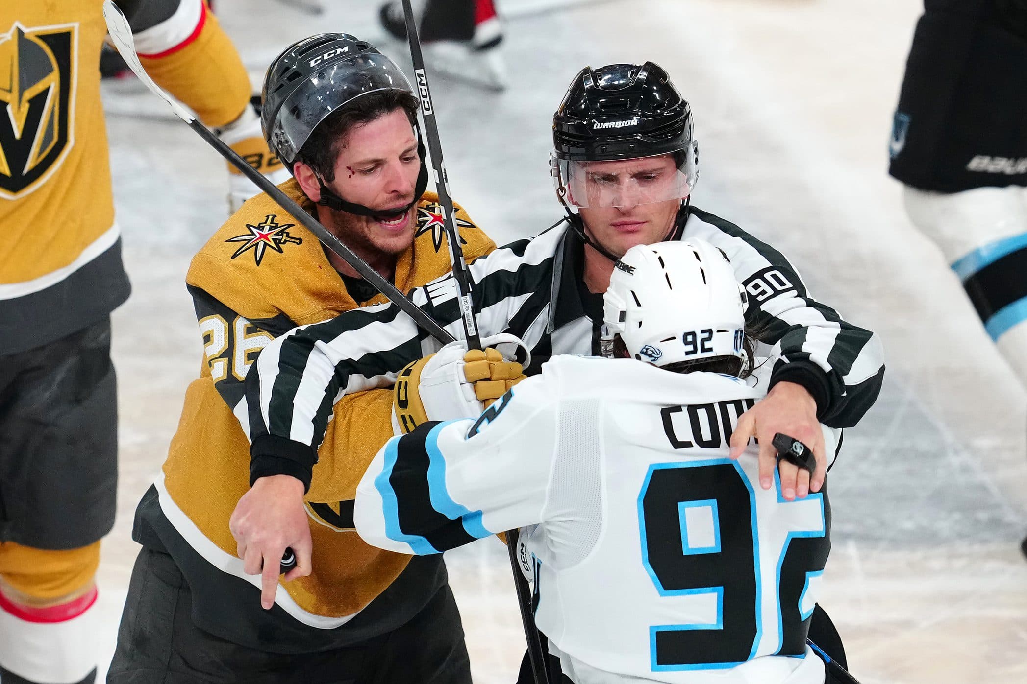 A linesman separates Vegas Golden Knights center Nic Dowd (26) and Utah Mammoth center Logan Cooley (92) after a third period face off during game one of the first round of the 2026 Stanley Cup Playoffs at T-Mobile Arena.