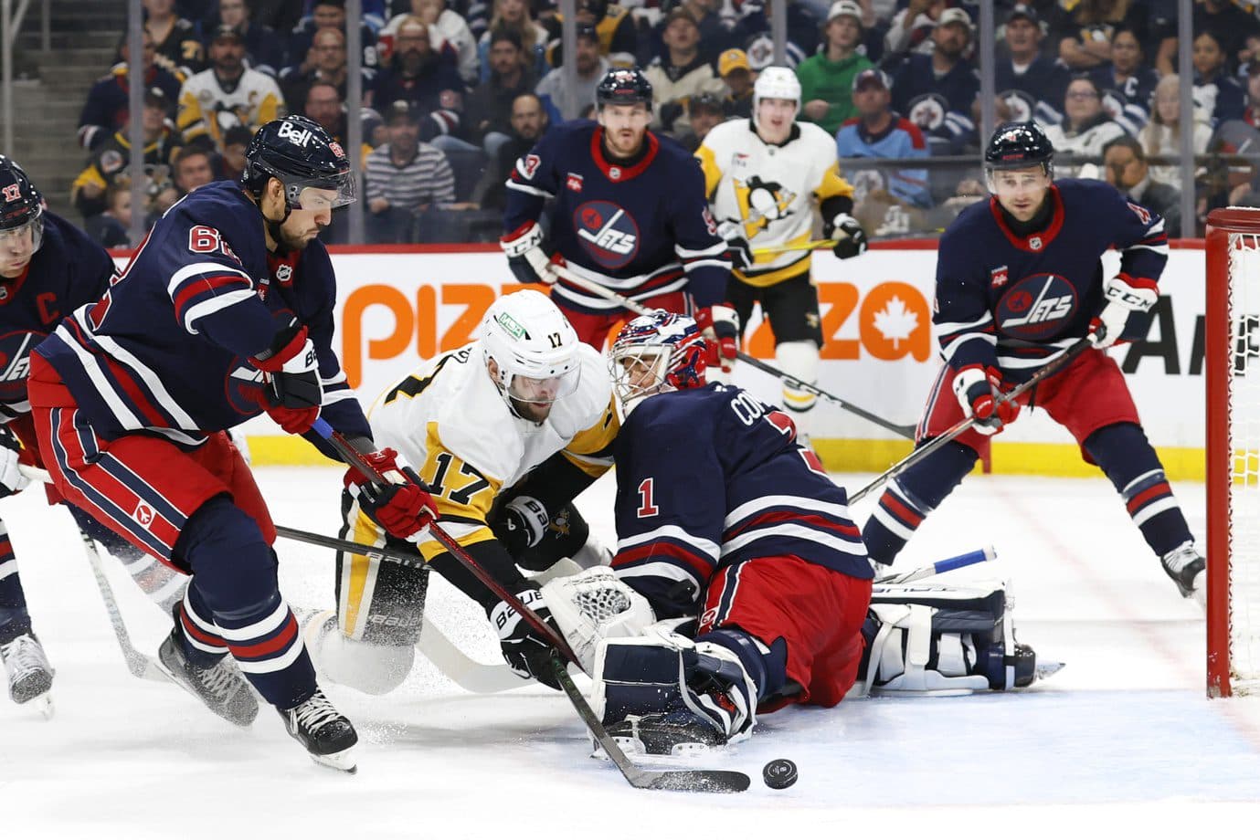 Winnipeg Jets right wing Nino Niederreiter (62) checks Pittsburgh Penguins right wing Bryan Rust (17) in front of Winnipeg Jets goaltender Eric Comrie (1) in the first period at Canada Life Centre