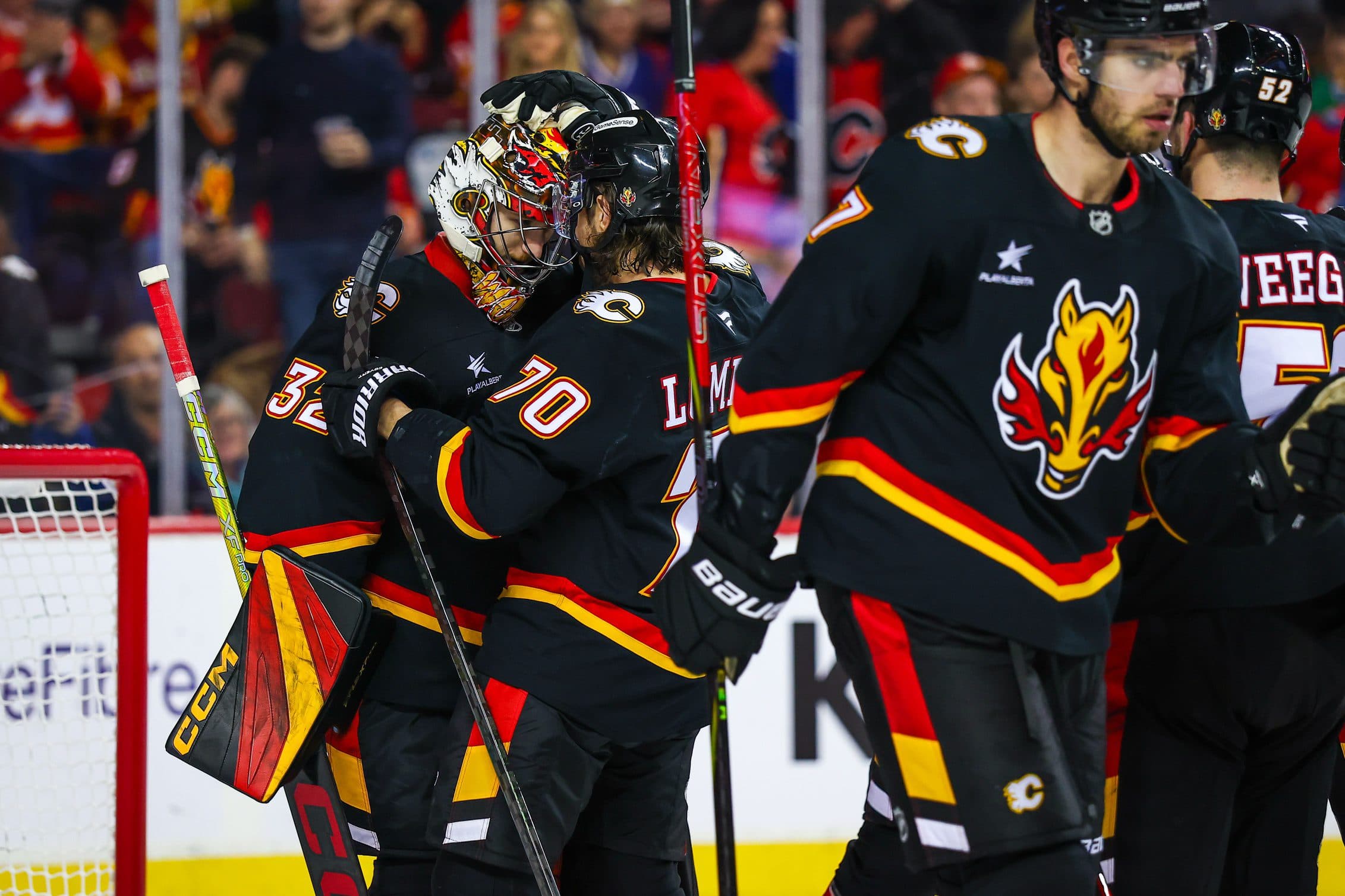 Calgary Flames goaltender Dustin Wolf (32) celebrate win with teammates after defeating Vancouver Canucks at Scotiabank Saddledome.