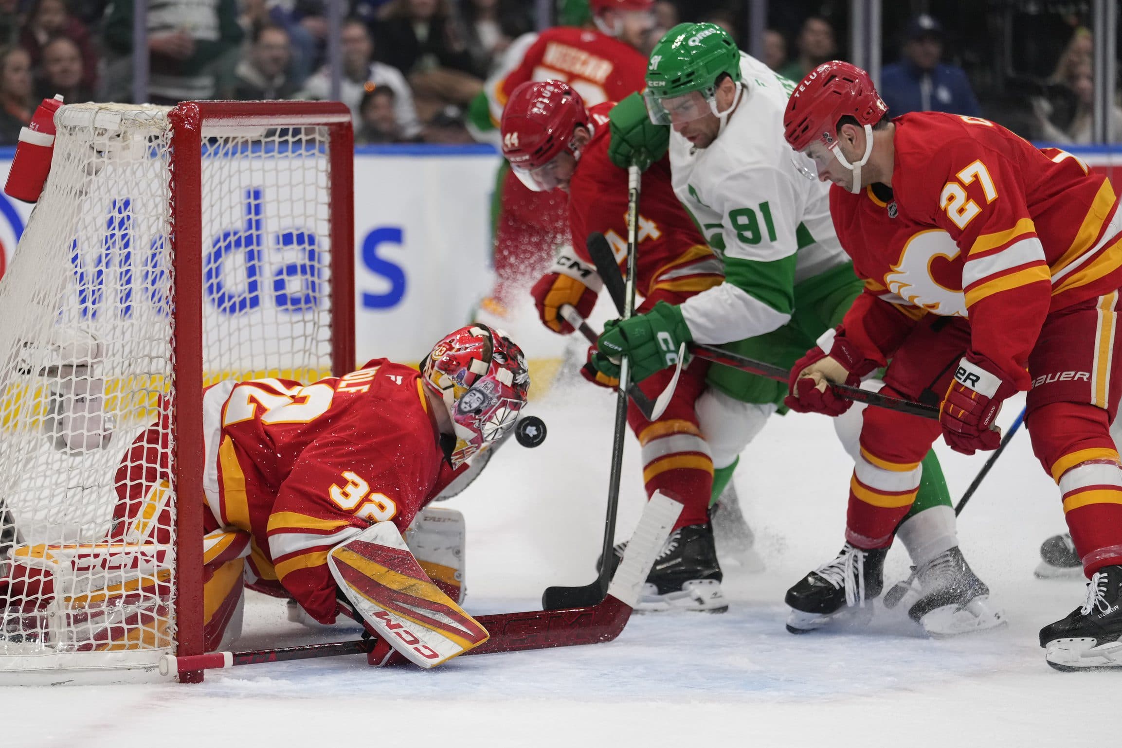 Calgary Flames goaltender Dustin Wolf (32) makes a save against Toronto Maple Leafs forward John Tavares (91) during the first period at Scotiabank Arena.