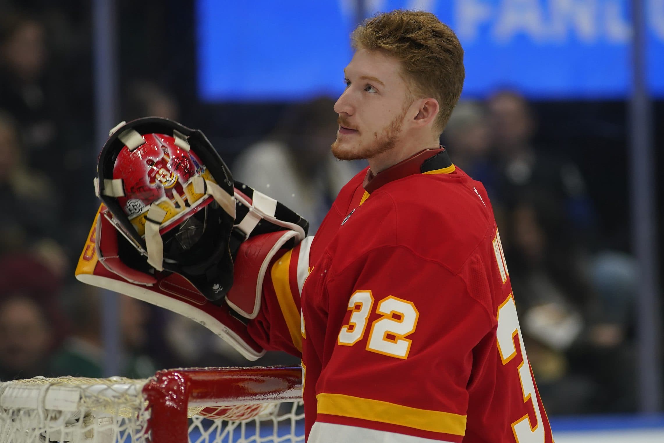 Calgary Flames goaltender Dustin Wolf (32) goes to put on his mask before a game against the Toronto Maple Leafs at Scotiabank Arena.
