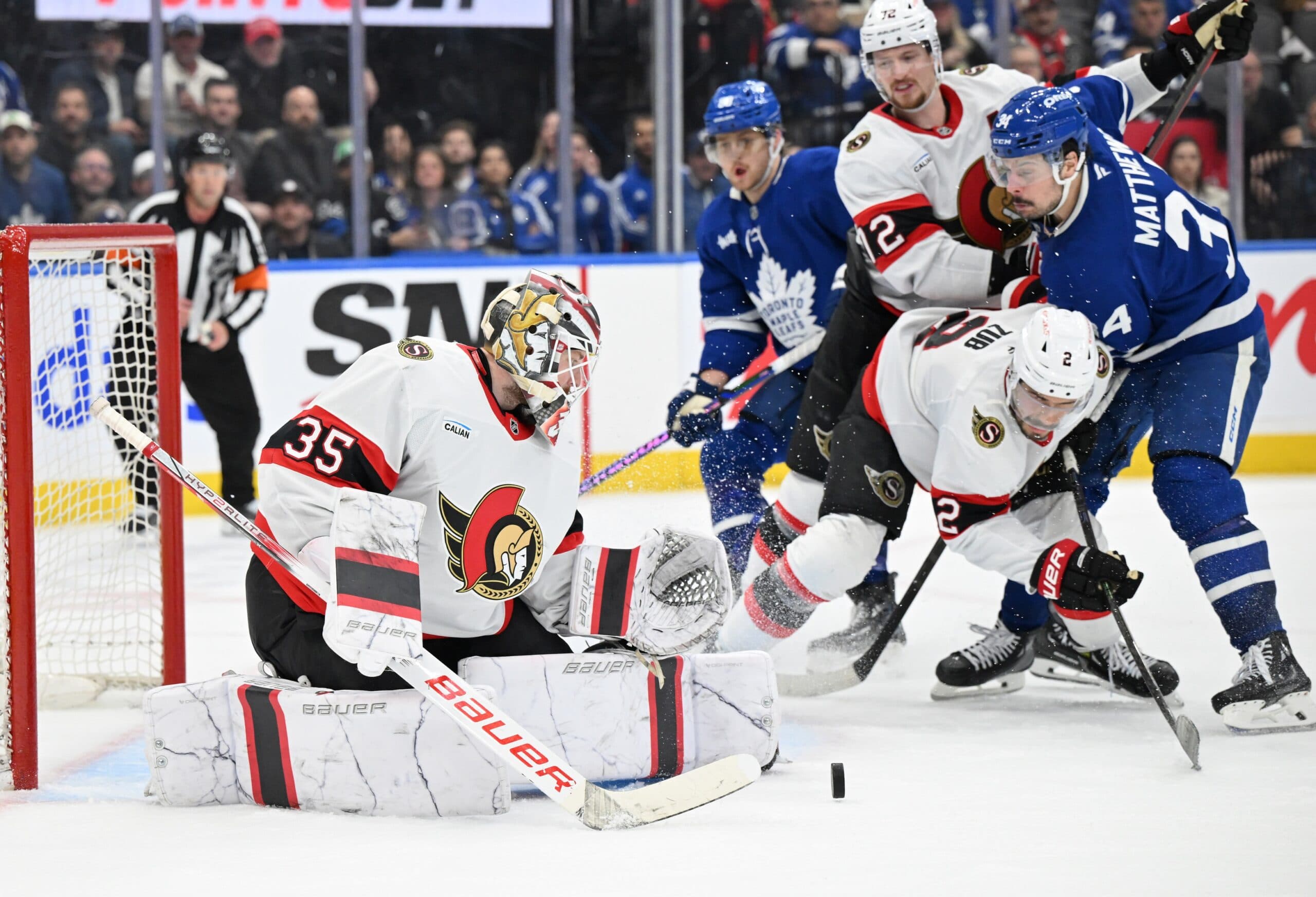 Ottawa Senators goalie Linus Ullmark (35) makes a save as defensemen Artem Zub (2) and Thomas Chabot (72) hold back Toronto Maple Leafs forward Auston Matthews (34) in the third period at Scotiabank Arena