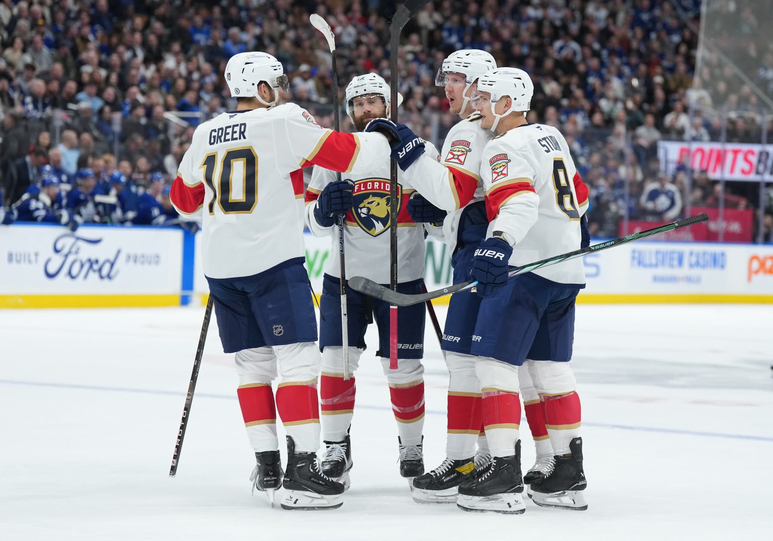 Florida Panthers defenseman Niko Mikkola (77) scores a goal and celebrates with left wing A.J. Greer (10) against the Toronto Maple Leafs during the second period at Scotiabank Arena.