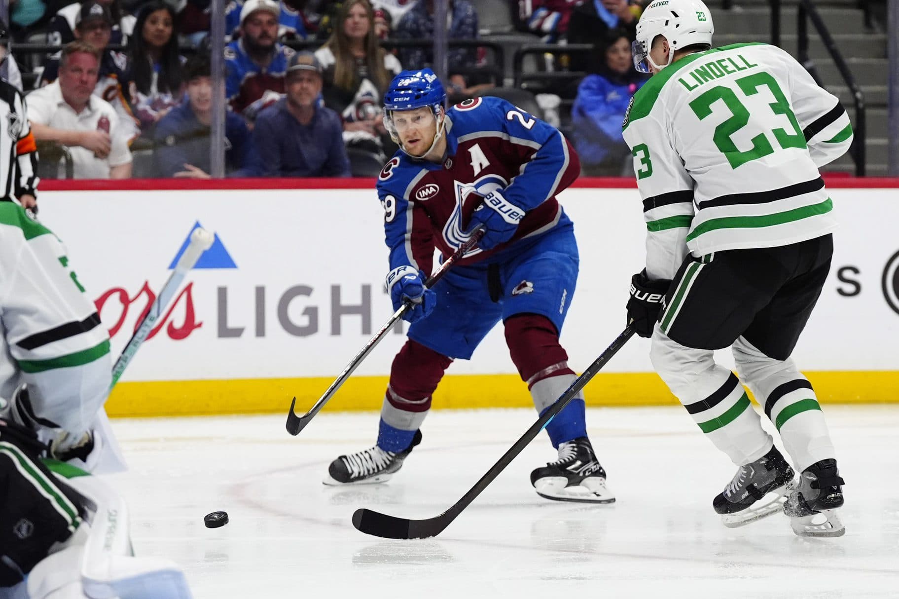Colorado Avalanche center Nathan MacKinnon (29) shoots the puck past Dallas Stars defenseman Esa Lindell (23) in the second period at Ball Arena.