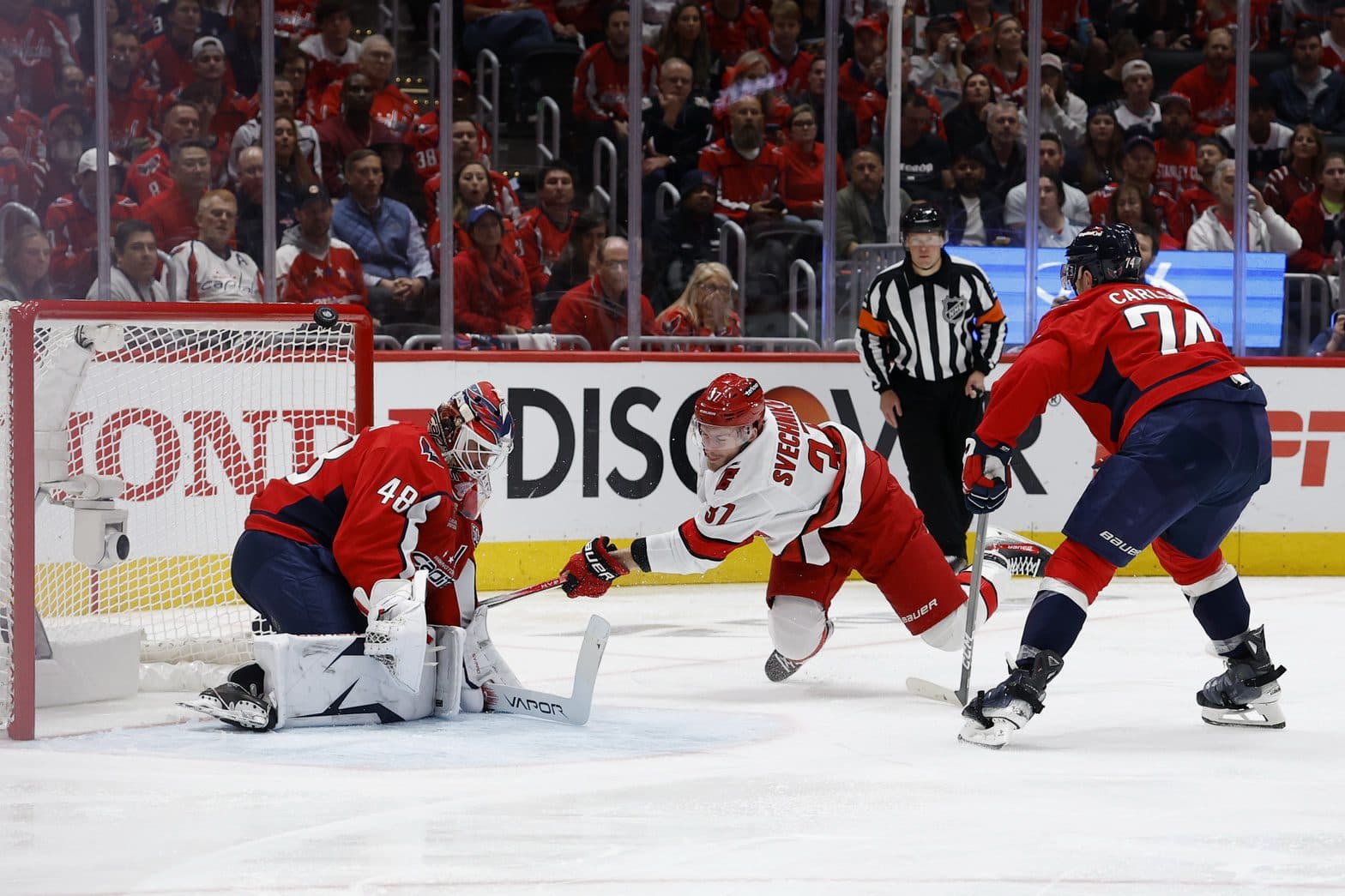 Washington Capitals goaltender Logan Thompson (48) makes a save on Carolina Hurricanes right wing Andrei Svechnikov (37) as Capitals defenseman John Carlson (74) defends in the second period in game two of the second round of the 2025 Stanley Cup Playoffs at Capital One Arena.