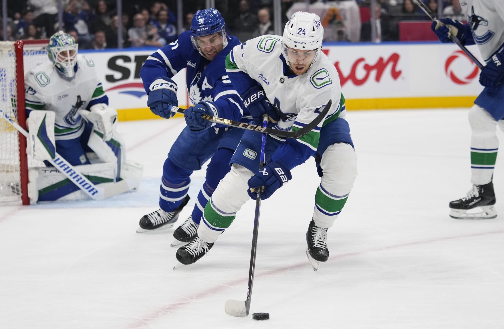 Vancouver Canucks forward Pius Suter (24) controls the puck against Toronto Maple Leafs forward John Tavares (91) during the first period at Scotiabank Arena.