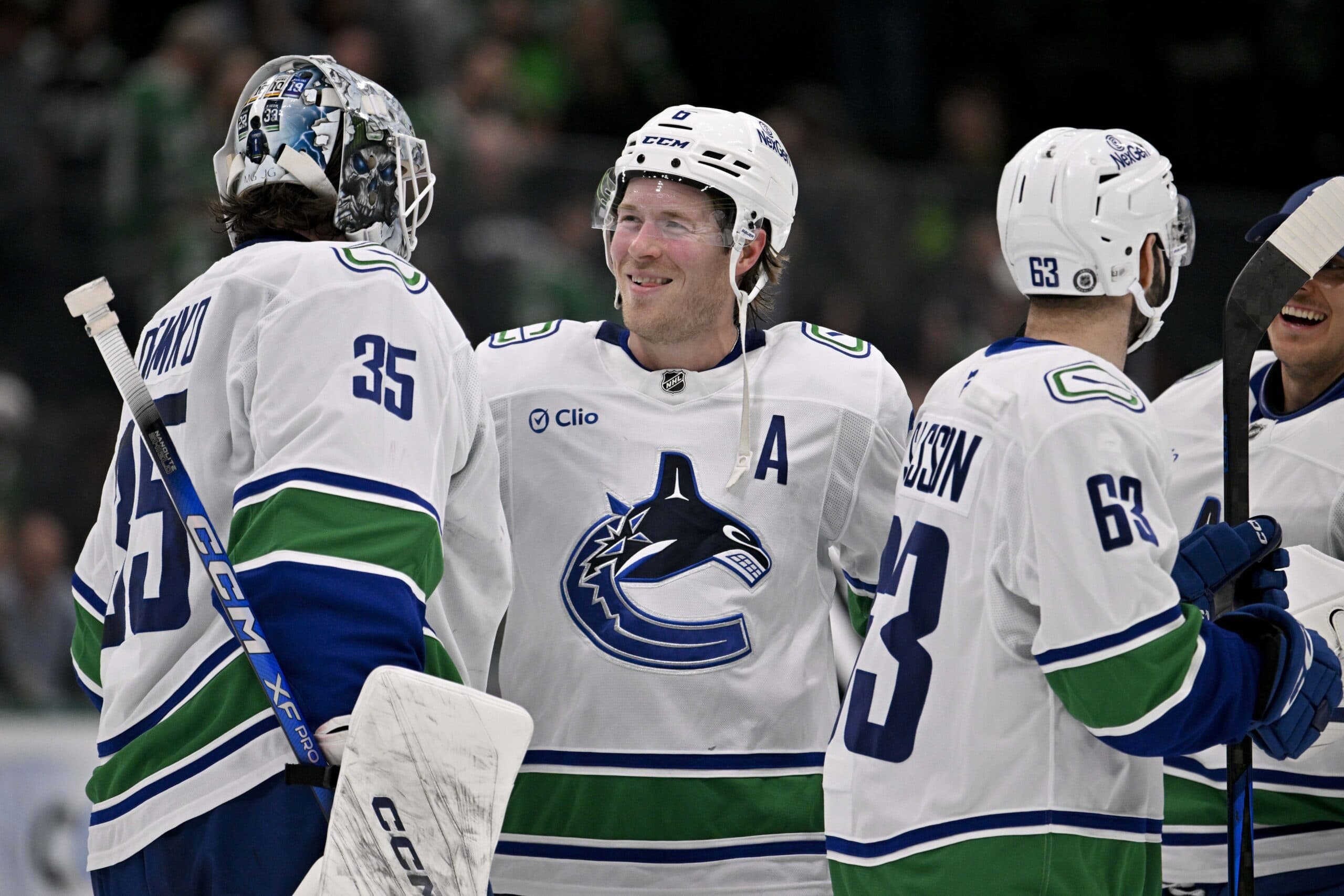 Vancouver Canucks goaltender Thatcher Demko (35) and right wing Brock Boeser (6) celebrate the victory over the Dallas Stars at the American Airlines Center.