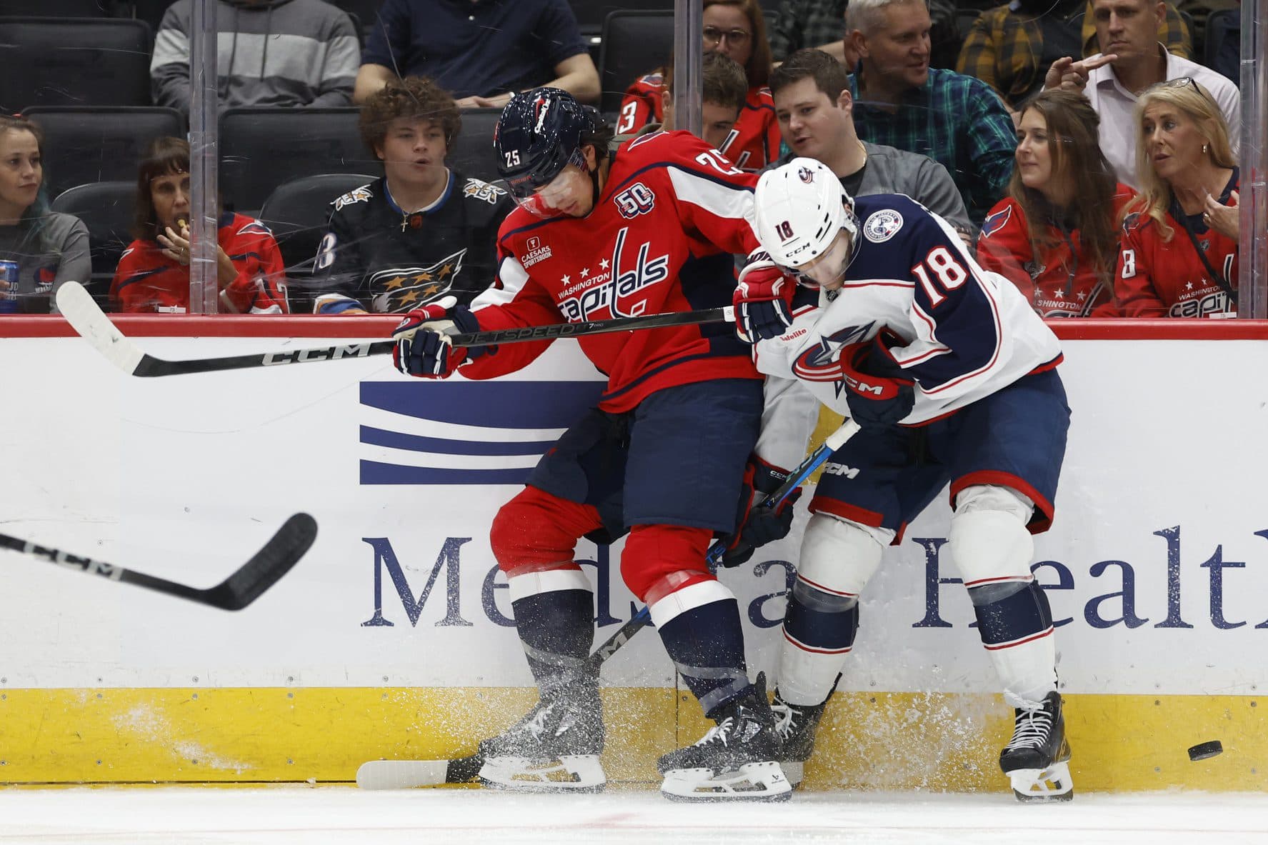 Washington Capitals defenseman Ethan Bear (25) and Columbus Blue Jackets center Dylan Gambrell (18) battle for the puck in the second period at Capital One Arena.
