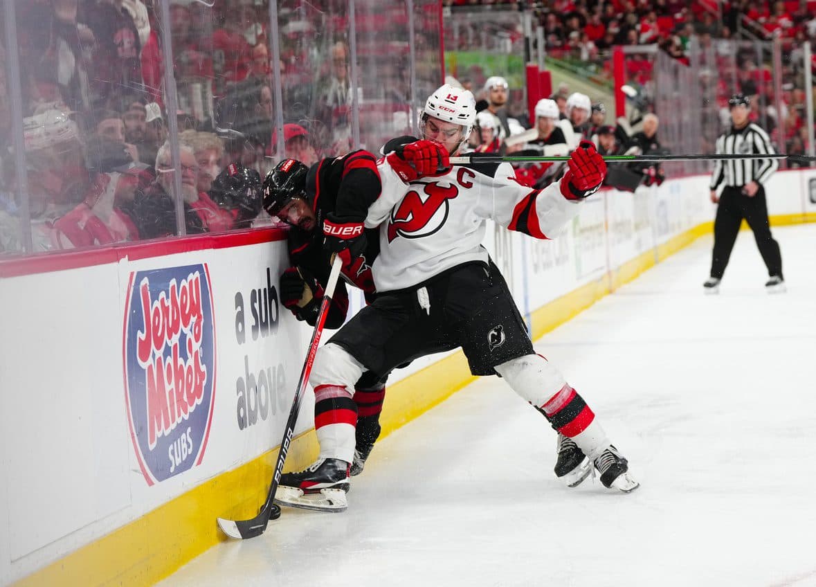 New Jersey Devils center Nico Hischier (13) checks Carolina Hurricanes center Seth Jarvis (24) during the second overtime in game five of the first round of the 2025 Stanley Cup Playoffs at Lenovo Center.