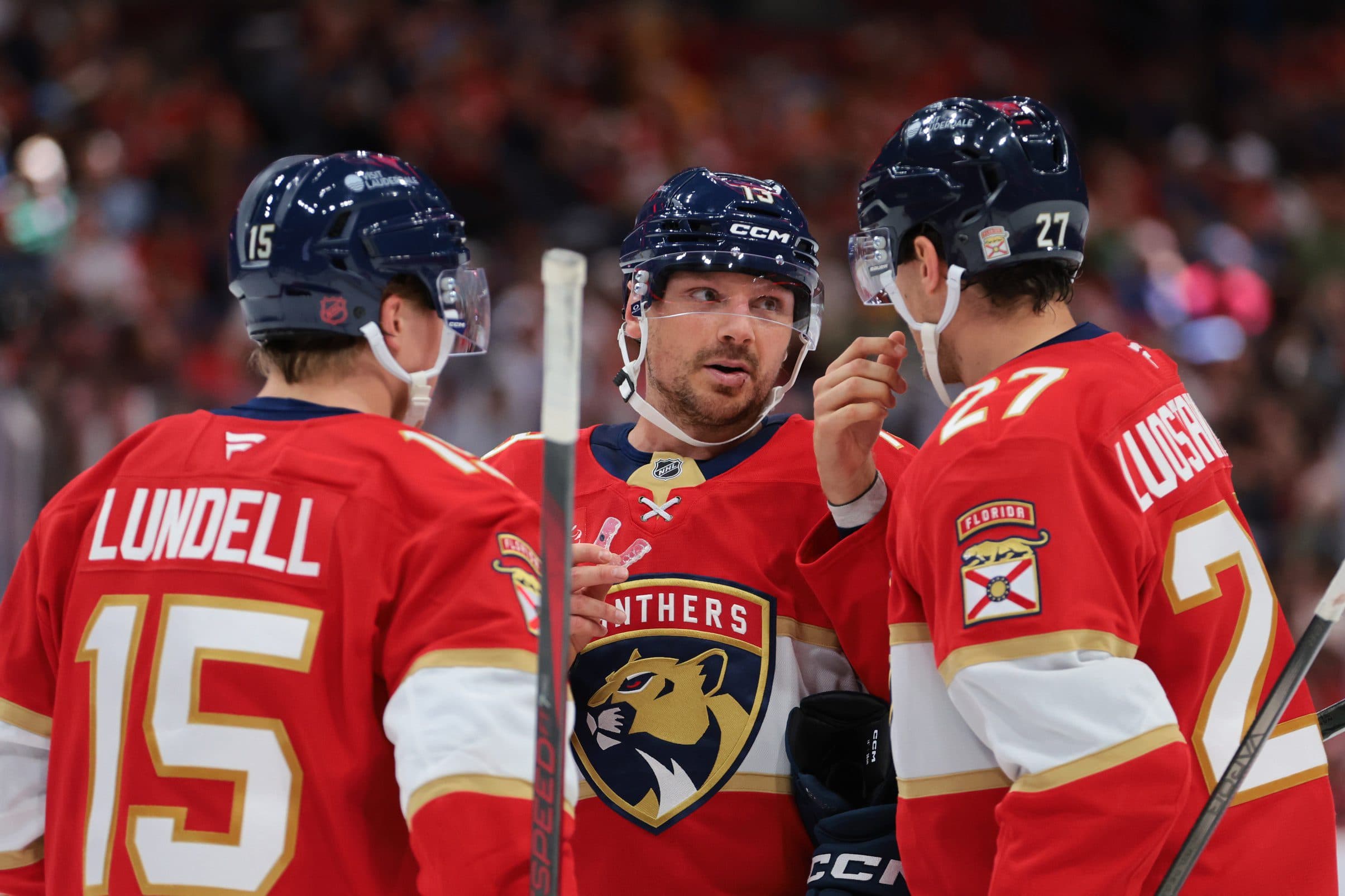 Florida Panthers center Sam Reinhart (13) speaks to center Anton Lundell (15) and center Eetu Luostarinen (27) against the Philadelphia Flyers during the second period at Amerant Bank Arena.
