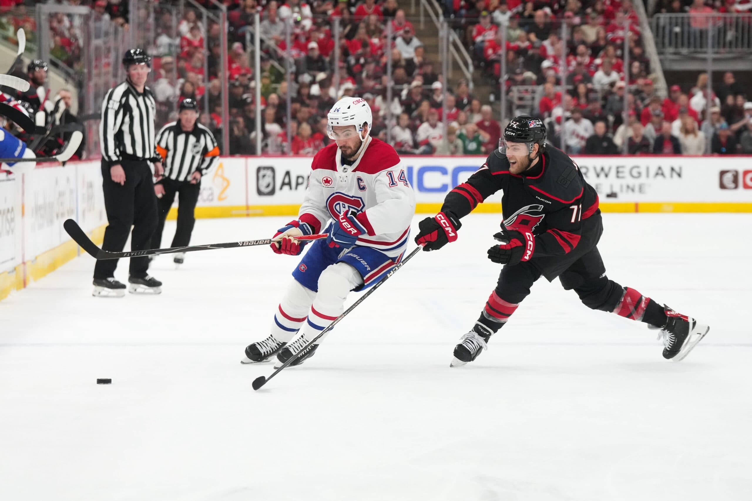 Montréal Canadiens center Nick Suzuki (14) skates with the puck as Carolina Hurricanes left wing Mark Jankowski (77) defends during the second period in game two of the Eastern Conferene Final of the 2026 Stanley Cup Playoffs at Lenovo Center.